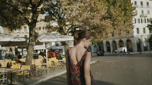 Beautiful blonde girl walking in narrow street in central Kerkyra, Greece on a sunny day