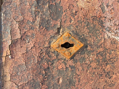 Old weathered chappy door with rusty keyhole photo