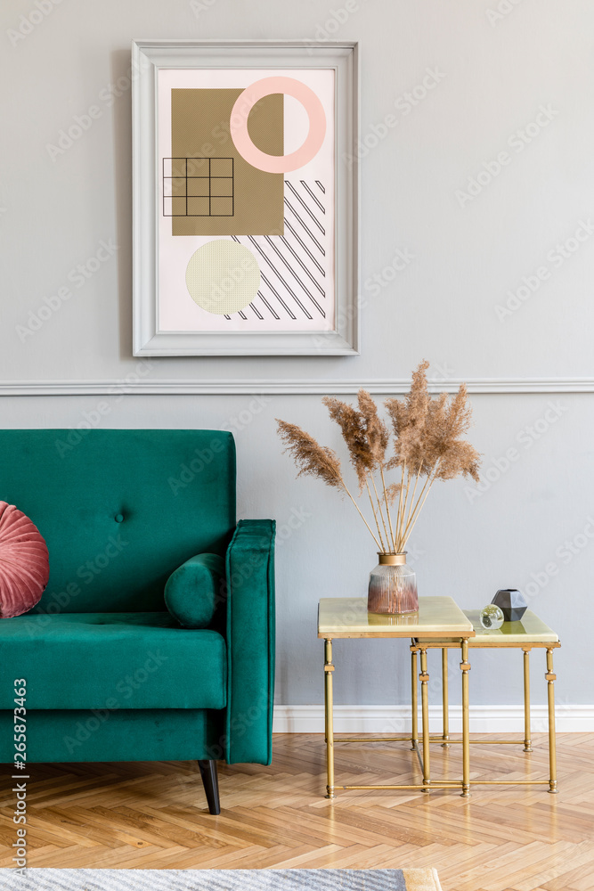Stylish and elegant living room of apartment interior with green velvet  sofa, gold coffee table, flowers and chic accessories. Mock up paintings  frame on the gray wall. Luxury home decor. Stock Photo