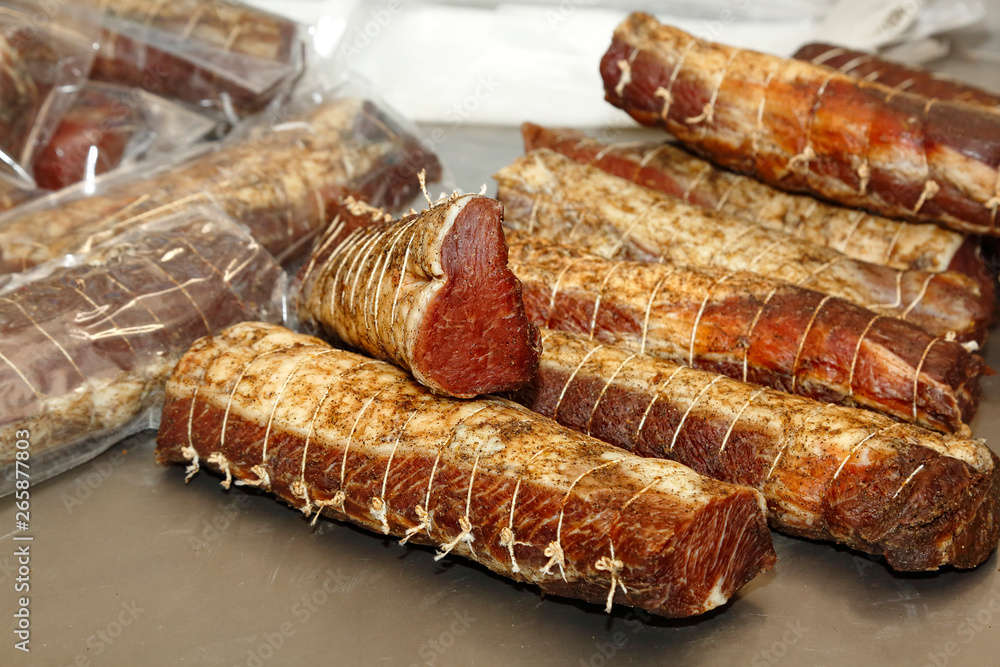 Smoked meat. Appetizing smoked meat. Enterprise manufacturer of delicacies. Delicious meat products. Food. The process of producing gourmet products. A lot of food. Sausage large. Rows of delicacie