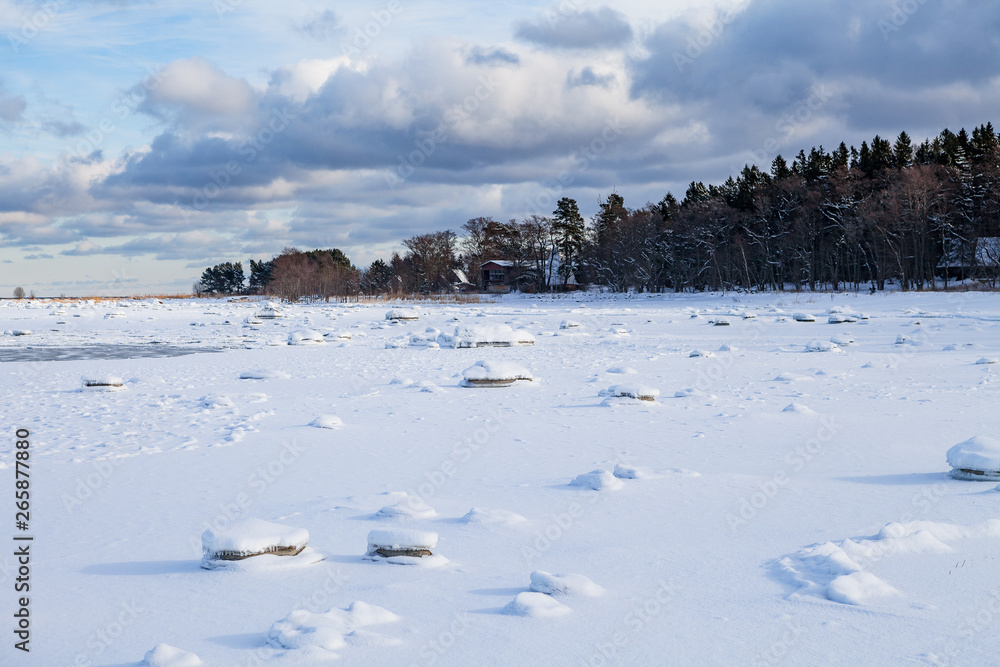 Frozen coast of Baltic sea covered by snow. Boulders, horizon and forest Frozen coast of Baltic sea covered by snow. Boulders, horizon and forest