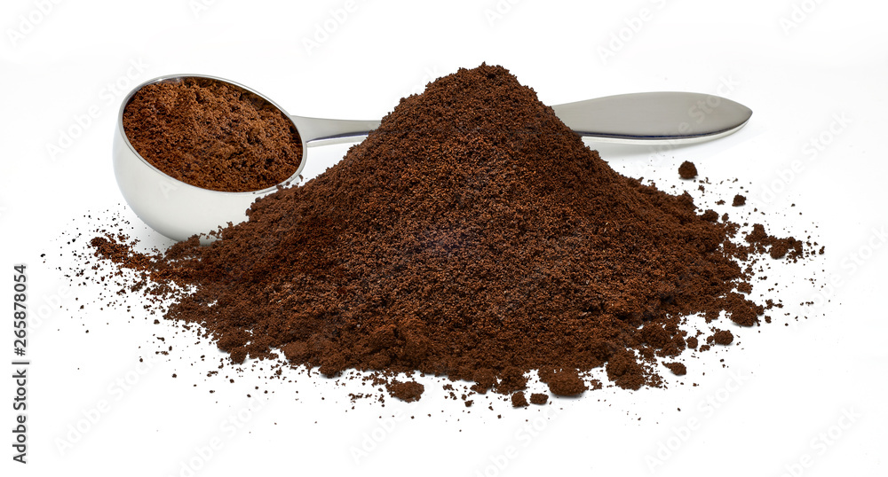 Metallic coffee measuring scoop with ground coffee pile isolated on white background Metallic coffee measuring scoop with ground coffee pile isolated on white background