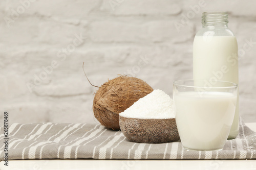 Coconut milk, coconut flakes and fresh brown coconut fruit. Organic vegan non-dairy plant-based milk.