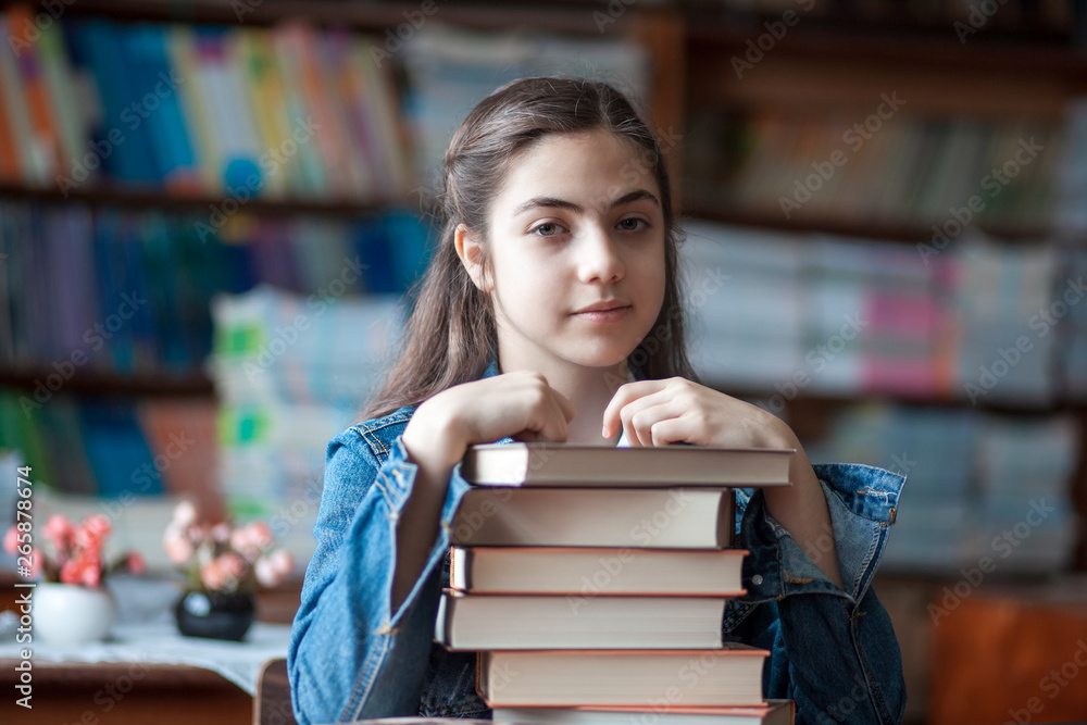 beautiful schoolgirl sitting in the library with books beautiful schoolgirl sitting in the library with books