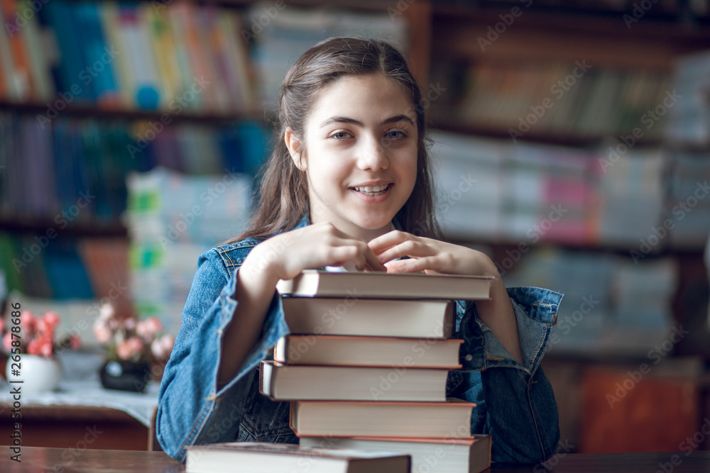 beautiful schoolgirl sitting in the library with books beautiful schoolgirl sitting in the library with books