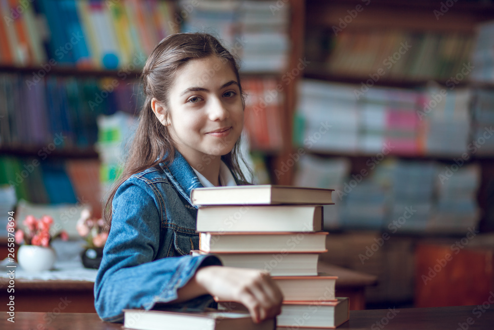 beautiful schoolgirl sitting in the library with books beautiful schoolgirl sitting in the library with books