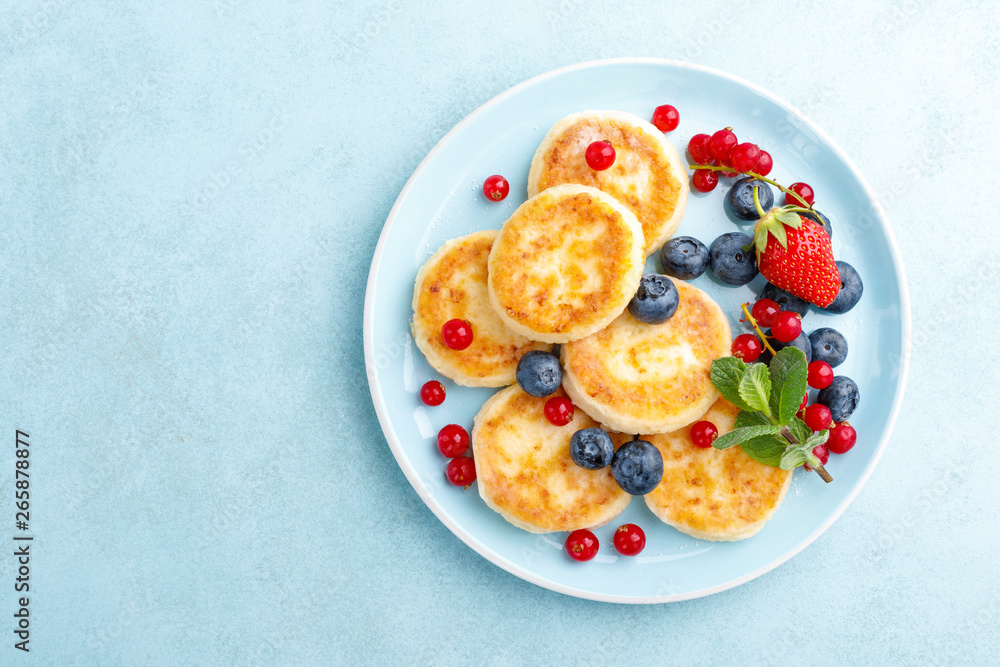 Cottage cheese pancakes, syrniki with fresh berries for breakfast