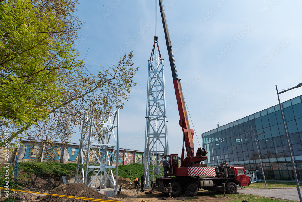 a large crane raises up the reflector structure