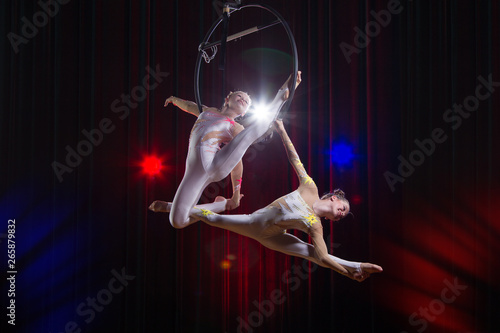 Circus actress acrobat performance. Two girls perform acrobatic elements in the air ring.