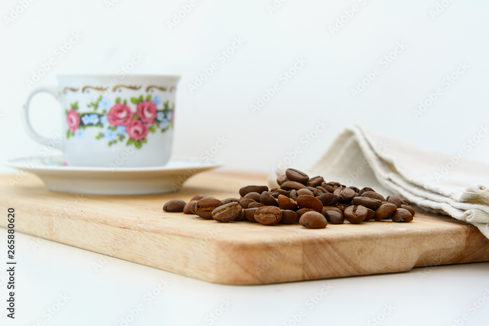 Fototapeta premium On the kitchen board is a coffee cup with a Chinese pattern, coffee beans and a linen towel. Concept - breakfast with coffee