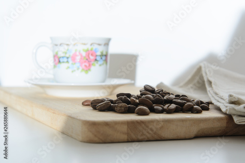 On the kitchen board is a coffee cup with a Chinese pattern  coffee beans and a linen towel. Concept - breakfast with coffee