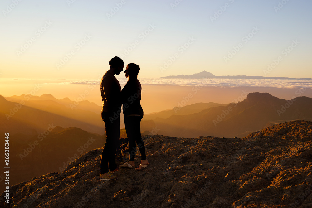 young kissing couple standing on mountain in front of golden sunset - silhouettes, gran canaria and tenerife young kissing couple standing on mountain in front of golden sunset - silhouettes, gran canaria and tenerife
