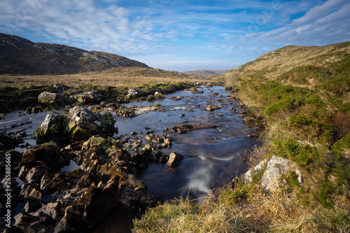 des rochers au milieu d’une rivière sauvage dans une plaine du Connemara