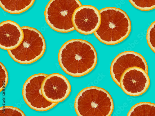 Creative pattern made of red oranges. top view of colorful fruit pattern of fresh red orange slices on blue colorful background. 