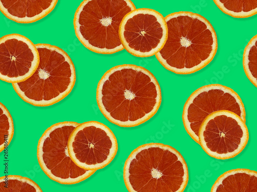 Creative pattern made of red oranges. top view of colorful fruit pattern of fresh red orange slices on green colorful background. 