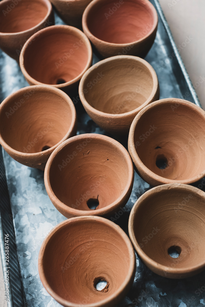 High angle close up of terracotta plant pots on metal tray. High angle close up of terracotta plant pots on metal tray.