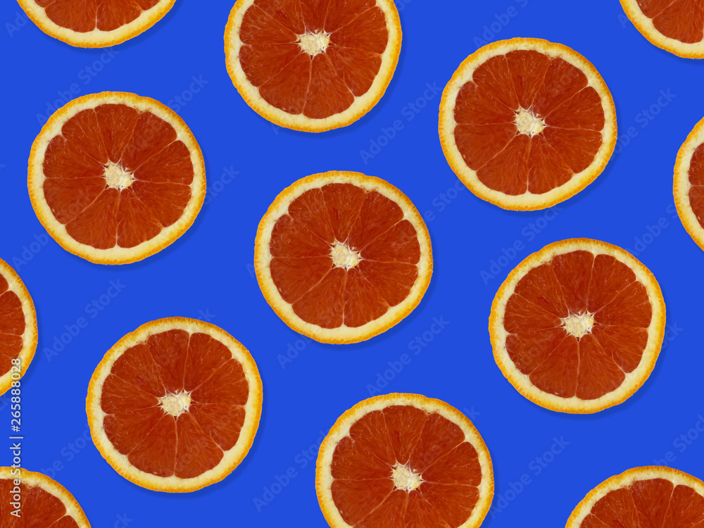 Creative pattern made of red oranges. top view of colorful fruit pattern of fresh red orange slices on blue colorful background. Creative pattern made of red oranges. top view of colorful fruit pattern of fresh red orange slices on blue colorful background.