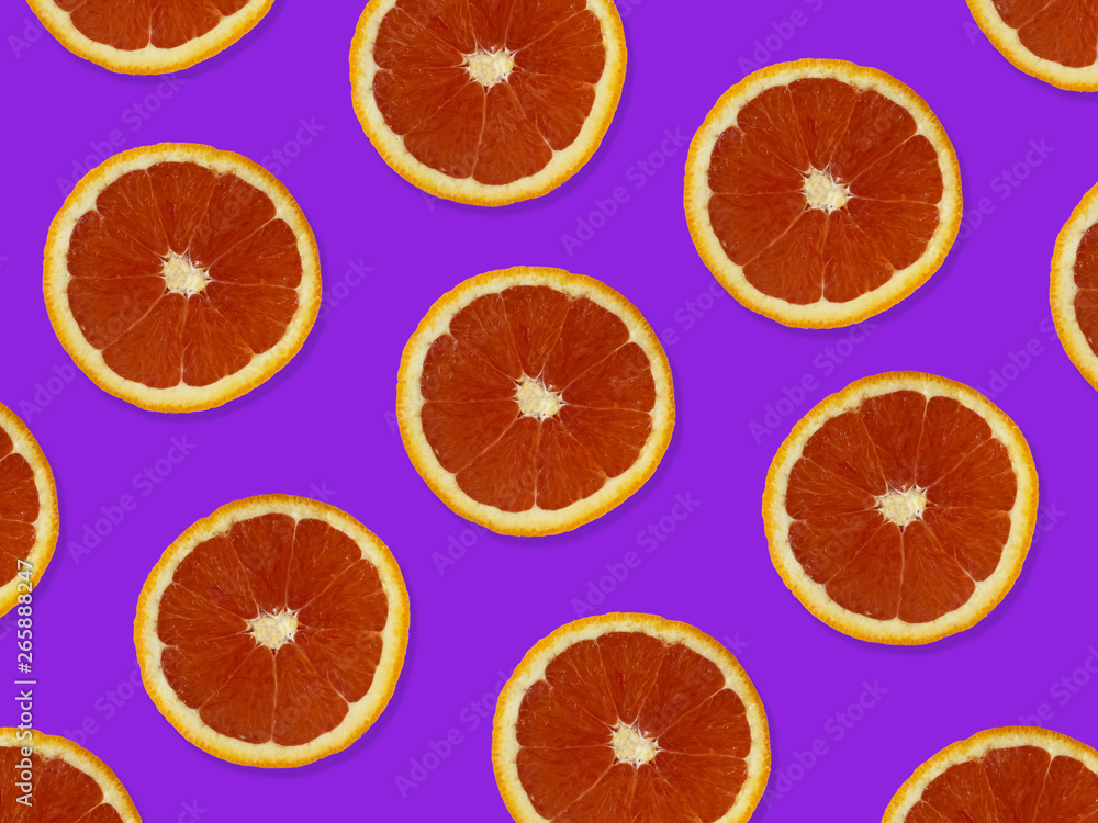Creative pattern made of red oranges. top view of colorful fruit pattern of fresh red orange slices on purple colorful background. Creative pattern made of red oranges. top view of colorful fruit pattern of fresh red orange slices on purple colorful background.