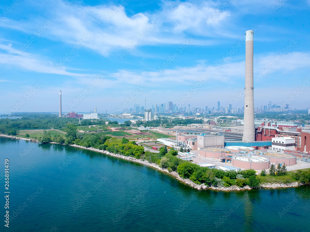 Fototapeta premium Modern urban wastewater treatment plant. Water purification plant, automatic process of removing chemicals, solids and gases from contaminated water. Water cleaning facility outdoors. Canada. Aerial.