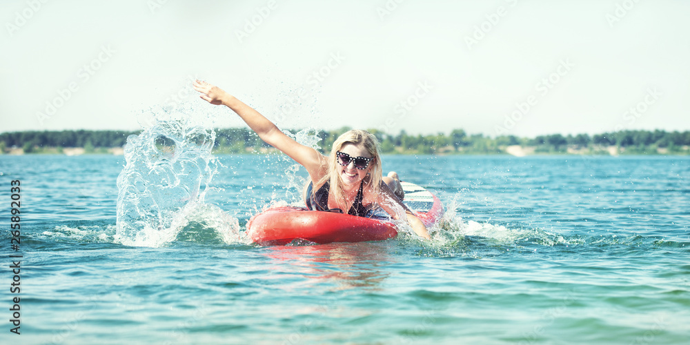 Young sexy woman swimming on paddle board.Water sports , active lifestyle.	