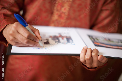 Принти на полотні Person signing guestbook at Indian wedding
