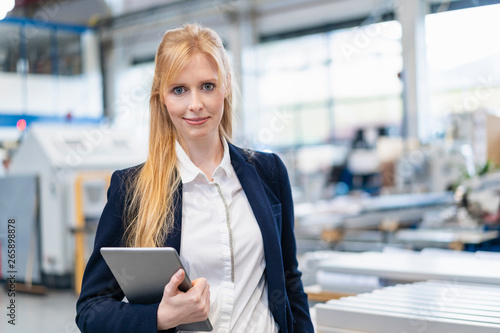 Portrait of confident businesswoman with tablet in factory