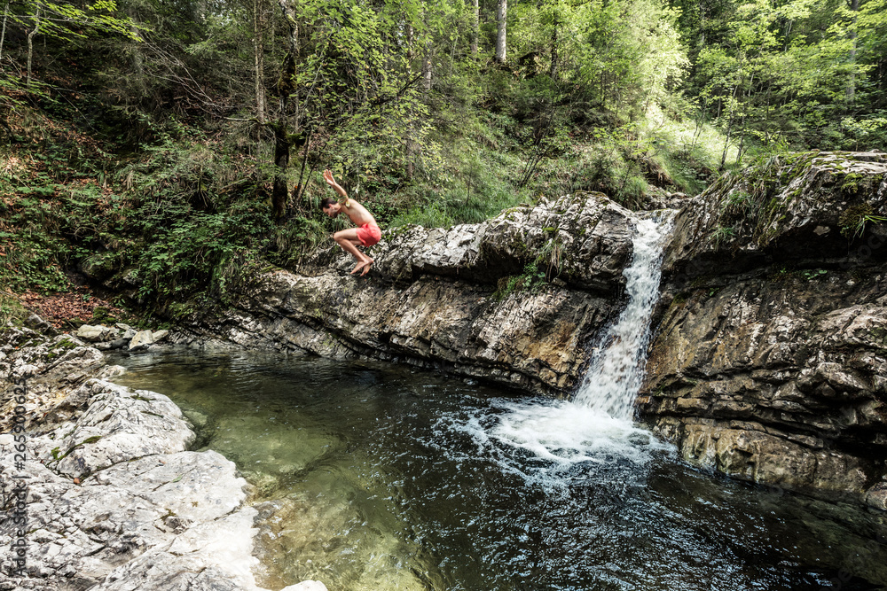 Germany, Upper Bavaria, Bavarian Prealps, lake Walchen, young man is jumping into a plunge pool Germany, Upper Bavaria, Bavarian Prealps, lake Walchen, young man is jumping into a plunge pool