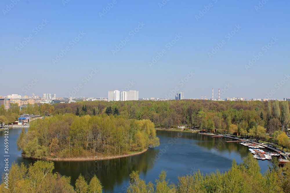 Panoramic view of the round pond and round island in the center of the pond in Izmailovsky Park in Moscow Russia on a spring day