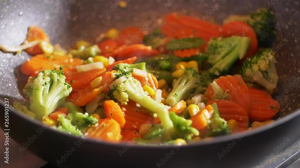 Slow motion of steaming vegetables on frying pan. Healthy lifestyle, vegetarian food, salad. Cooking process, homemade dish. Organic food, delicious taste. Close up view