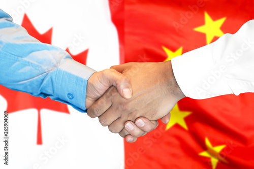 Canvas Print Business handshake on the background of two flags
