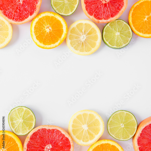 Colorful fruit double border of fresh citrus slices. Top view, flay lay over a white background with copy space.