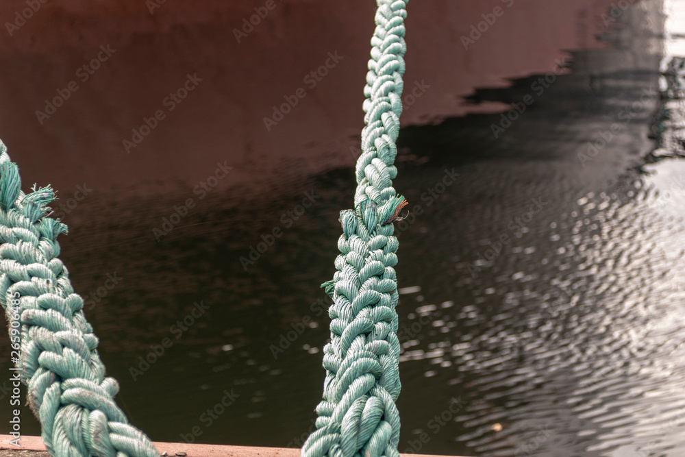 Fototapeta premium A big rope of the ship on the metal it is a knot rope that holds the ship in dock