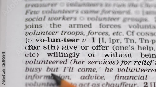 Volunteer word pointed in dictionary, doing or offering help without being paid photo