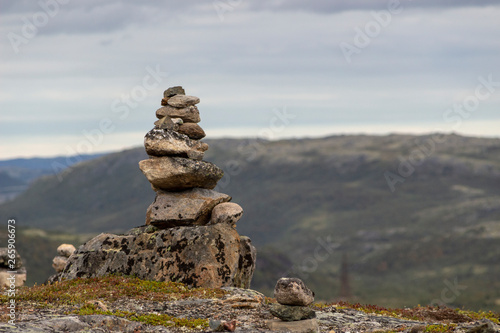 Stones stacked for Norwegian fairytale trolls. Relief and texture of stone with patterns and moss. Stone natural background. Stone with Moss. Stones boulders covered with moss. © AleksViking