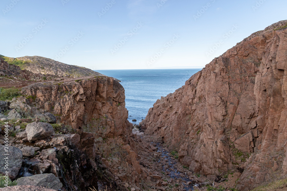 river meets ocean along a rocky shoreline with heavy water flow in a forest area, Motion river