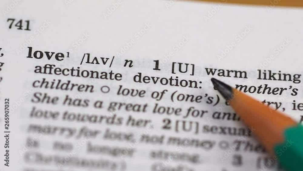 Love definition pointed by pencil in vocabulary, commitment to partner happiness Love definition pointed by pencil in vocabulary, commitment to partner happiness