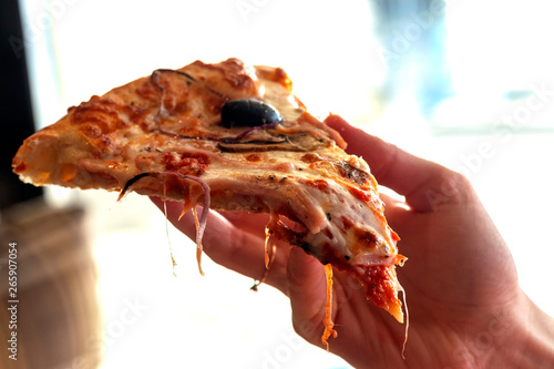 Hand taking slice of delicious pizza