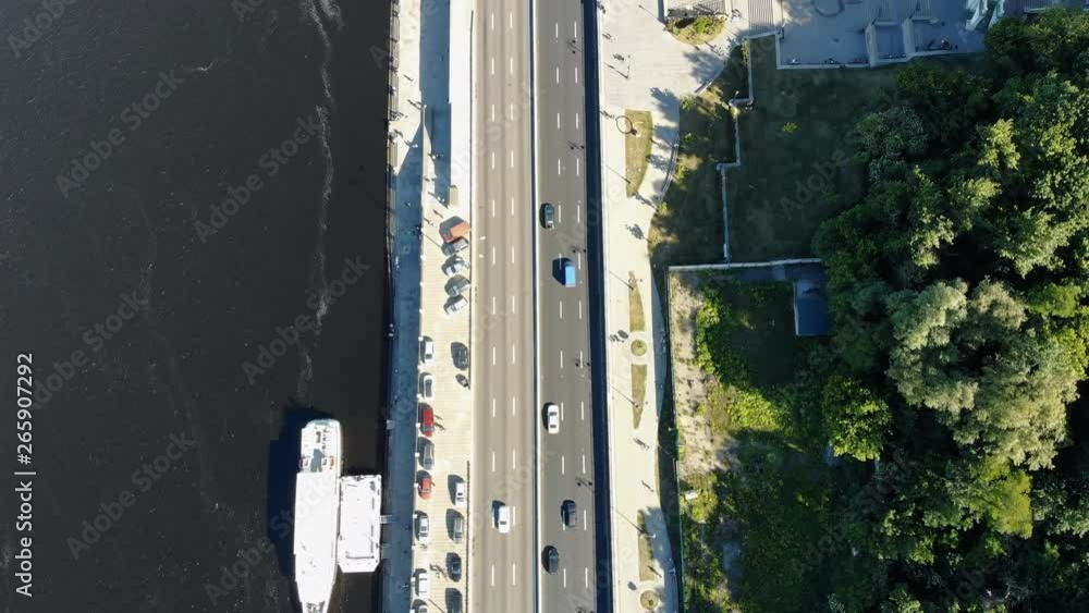 Top drone view of the beautiful river coastline and busy street in the city. Modern summer cityscape. Top drone view of the beautiful river coastline and busy street in the city. Modern summer cityscape.