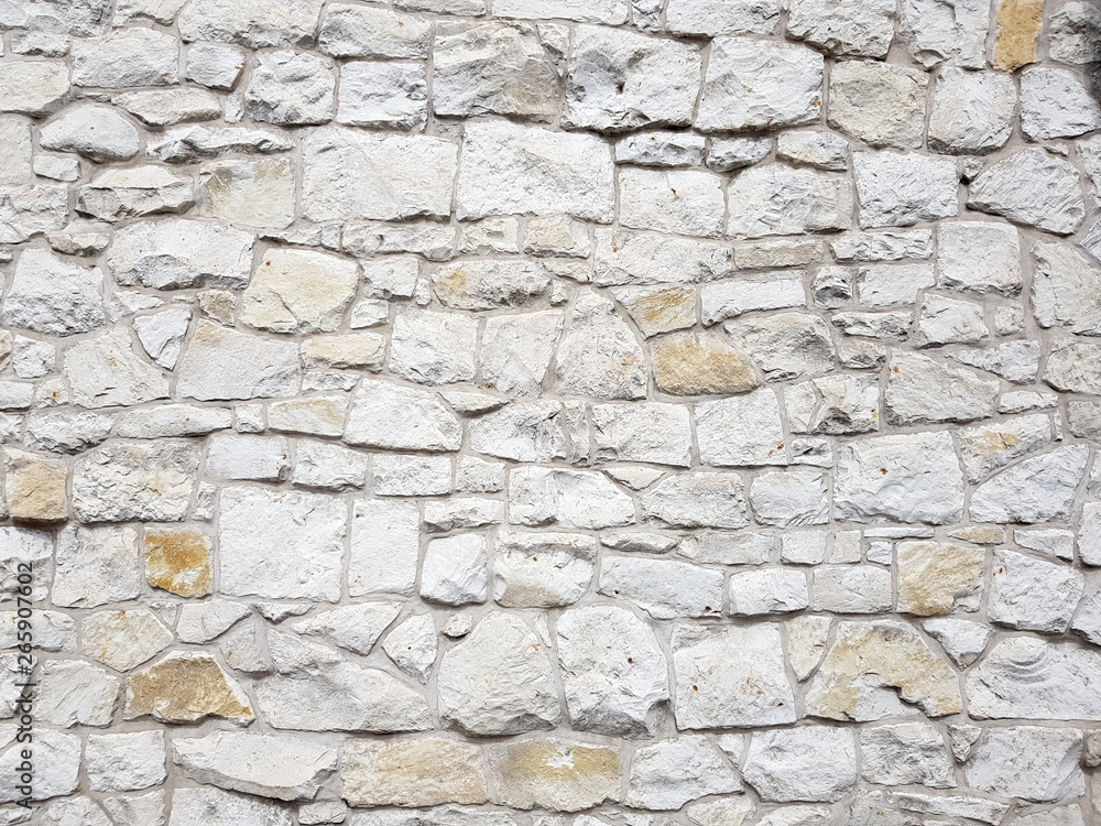 Fototapeta premium Old bright white pattern stone wall texture.