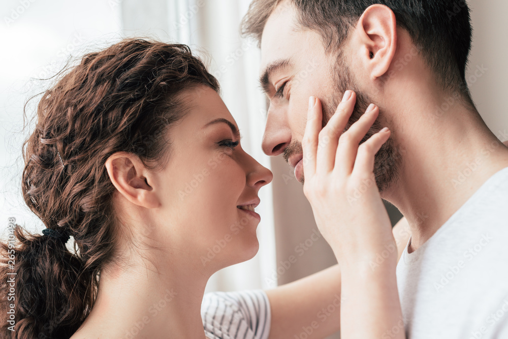 happy smiling woman stroking bearded boyfriend at home happy smiling woman stroking bearded boyfriend at home