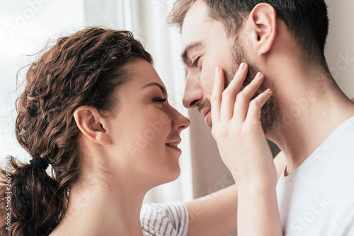 Slika na platnu happy smiling woman stroking bearded boyfriend at home