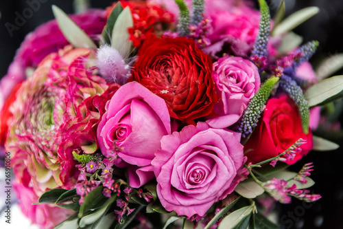 Exquisite bridal bouquet of red and pink roses in combination with wildflowers
