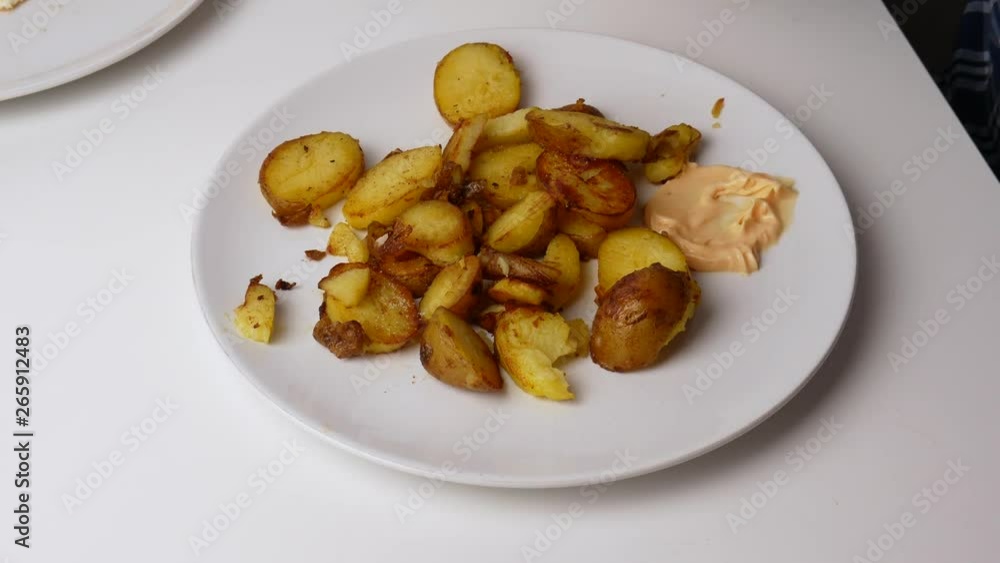Close up. Fried potatoes are put on a fork and dipped in cheese sauce. Close up. Fried potatoes are put on a fork and dipped in cheese sauce.