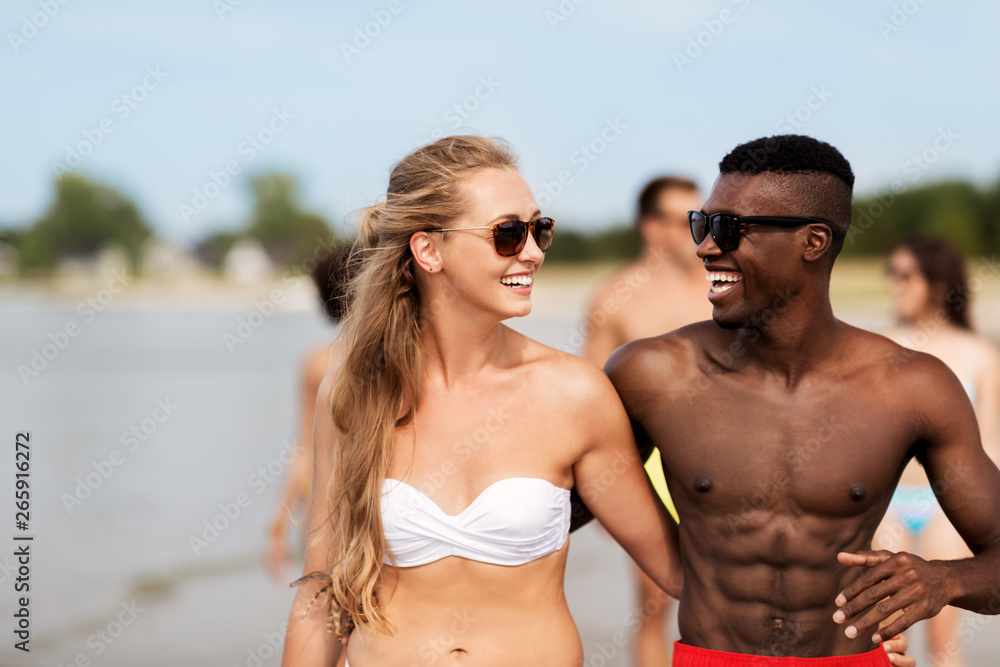friendship, summer holidays and people concept - happy friends or couples hugging on beach friendship, summer holidays and people concept - happy friends or couples hugging on beach