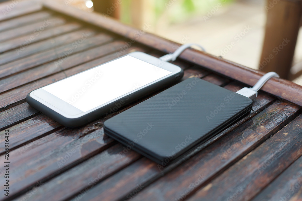 Smartphone and powerbank on wooden table. Smartphone and powerbank on wooden table.