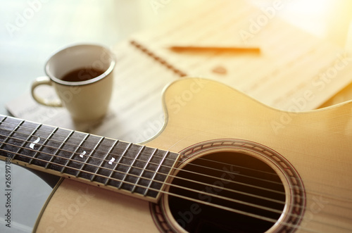 Acoustic guitar and  a cup of coffee on  background