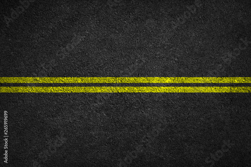 Structure of granular asphalt. Asphalt texture with two yellow line road marking. Abstract road background.