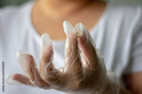 Wallpaper Mural Hand in white latex surgical glove holding a pill Torontodigital.ca