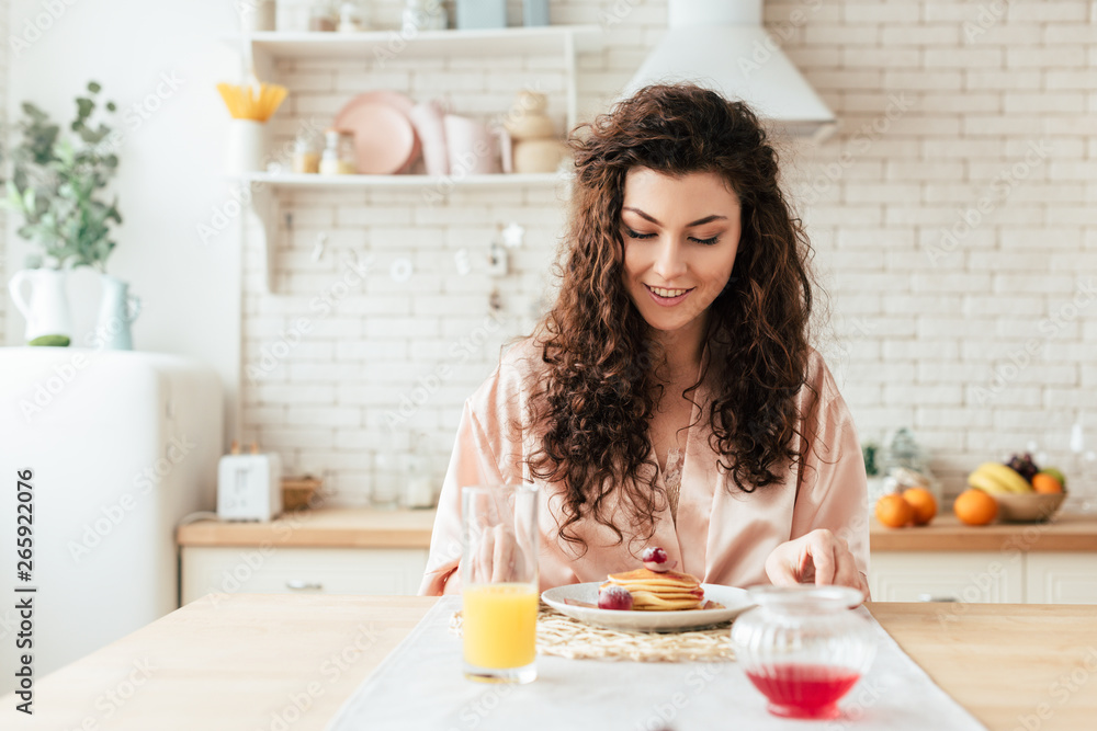 charming curly girl looking at pancakes with smile charming curly girl looking at pancakes with smile