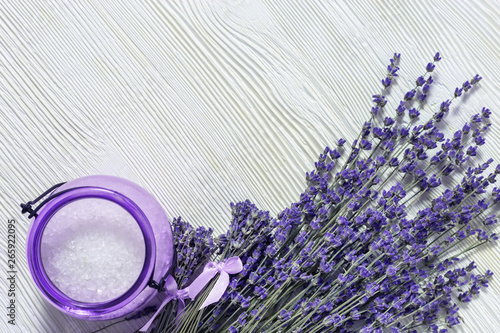 Lavender flowers and jar with sea salt on white wooden surfase. Spa background with copy space. Selective focus. photo
